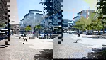 A man walks past a large glass building, the New Chair of Architecture and Nursing at ETH Zurich